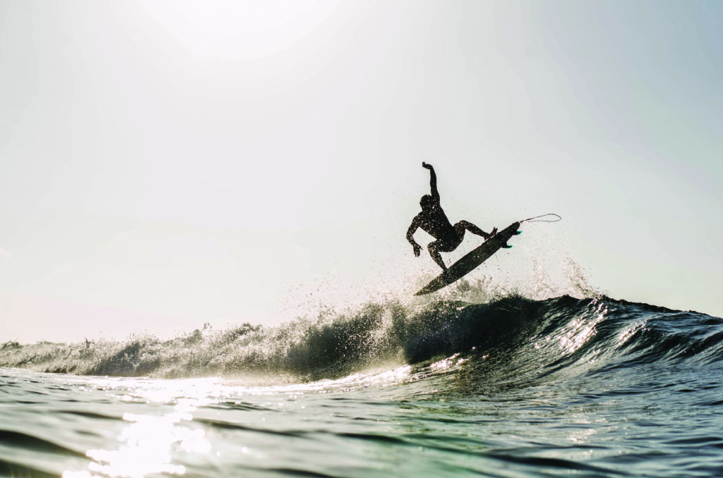 Surfer doing an aerial maneuver on a wave